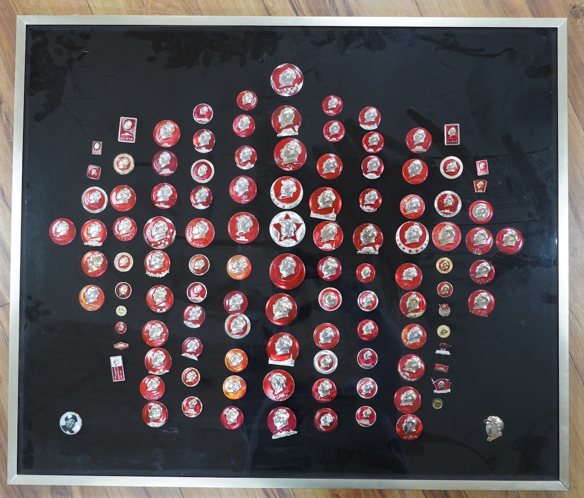 A display case of Chinese red enamelled badges with the head of Chairman Mao, 72 x 85cm